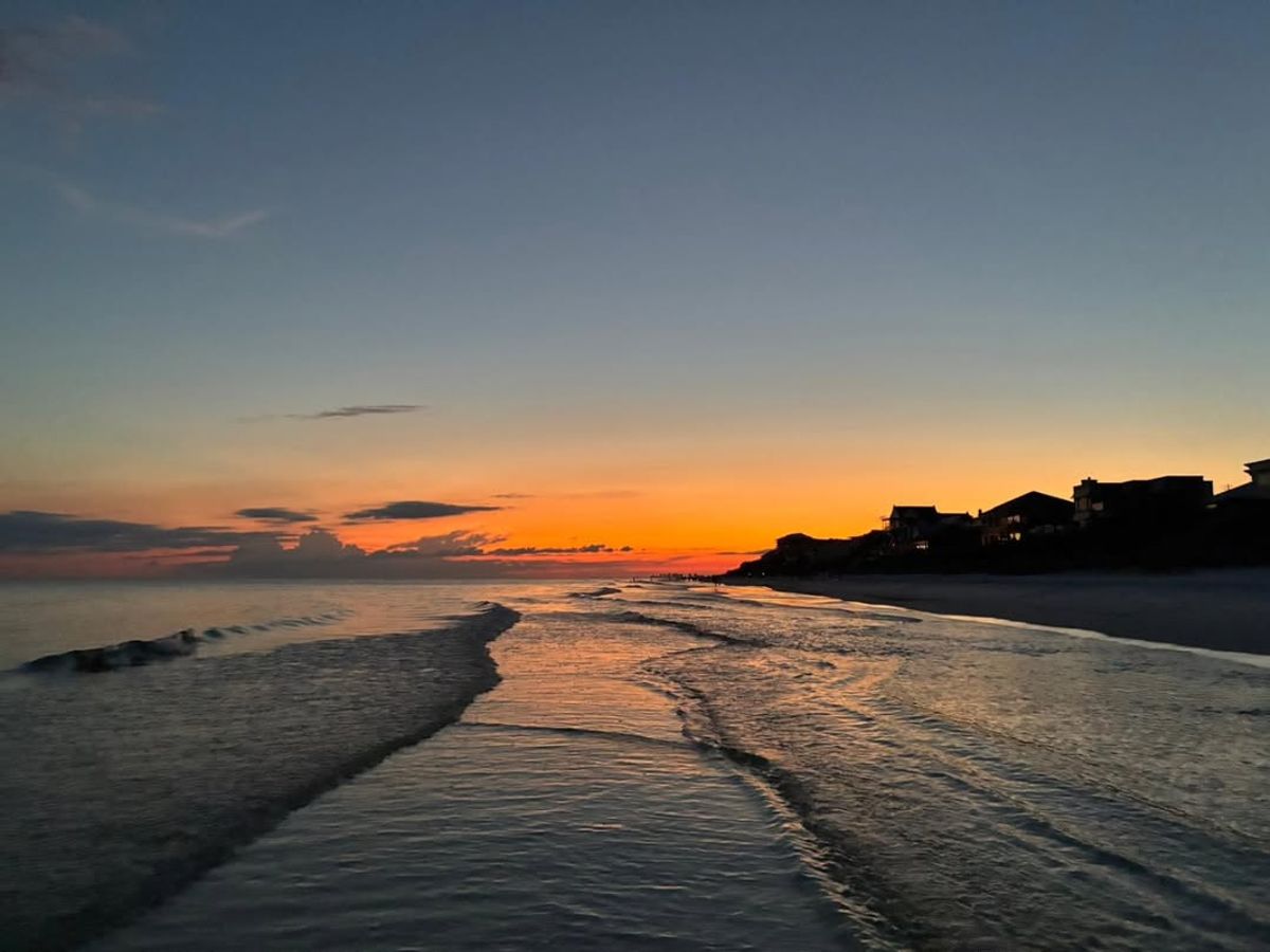 Blue Mountain Beach shows off its colorful skies and calm shoreline as the sun sets over the Gulf of Mexico. Known for its laid-back vibe, this beach offers both natural beauty and a relaxed local charm.