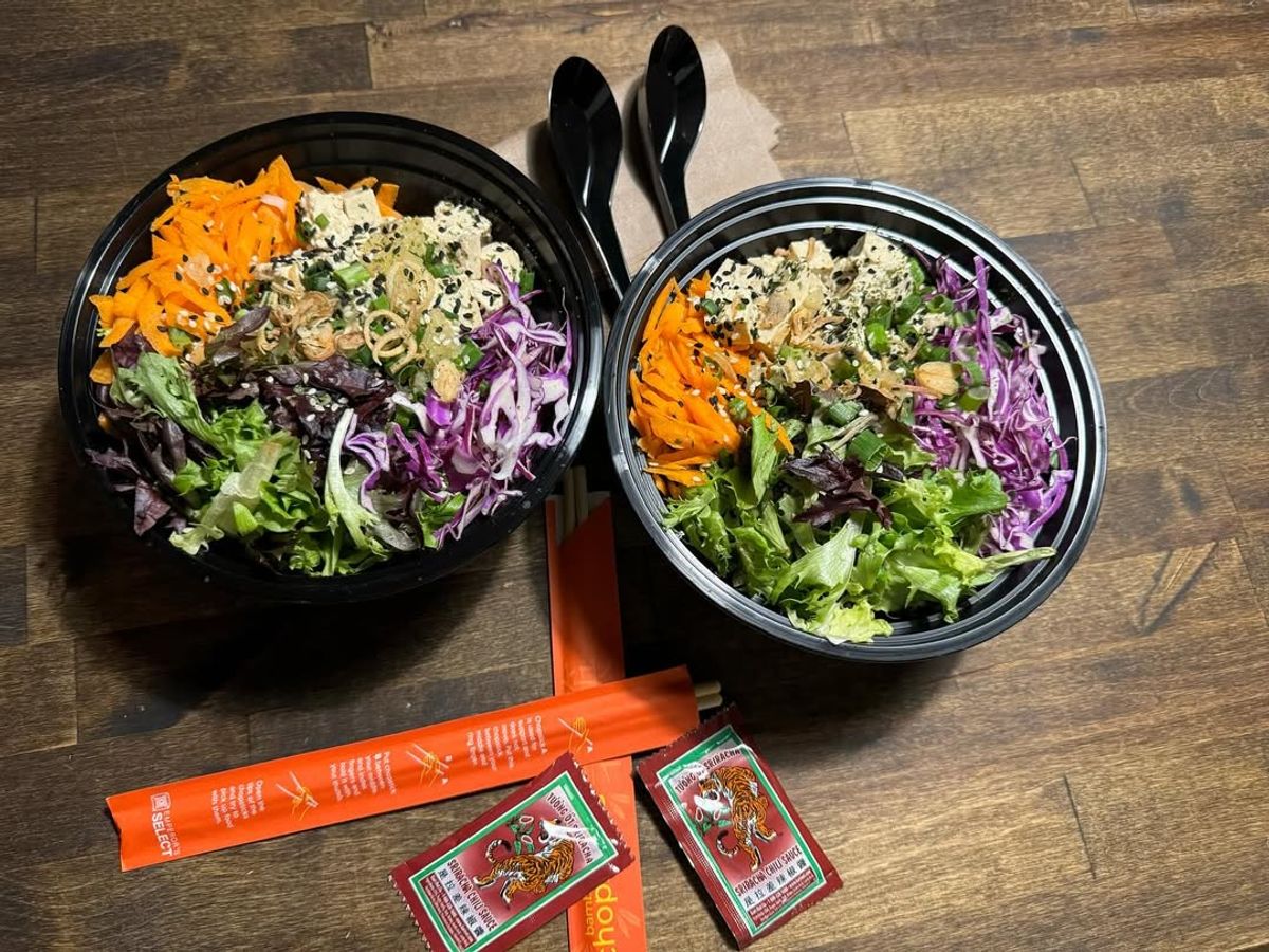 Two colorful poke bowls are filled with fresh greens, shredded carrots, purple cabbage, and tofu, topped with sesame seeds. The vibrant plant-based meal showcases Kelley Farm Kitchen’s healthy and flavorful dining style.