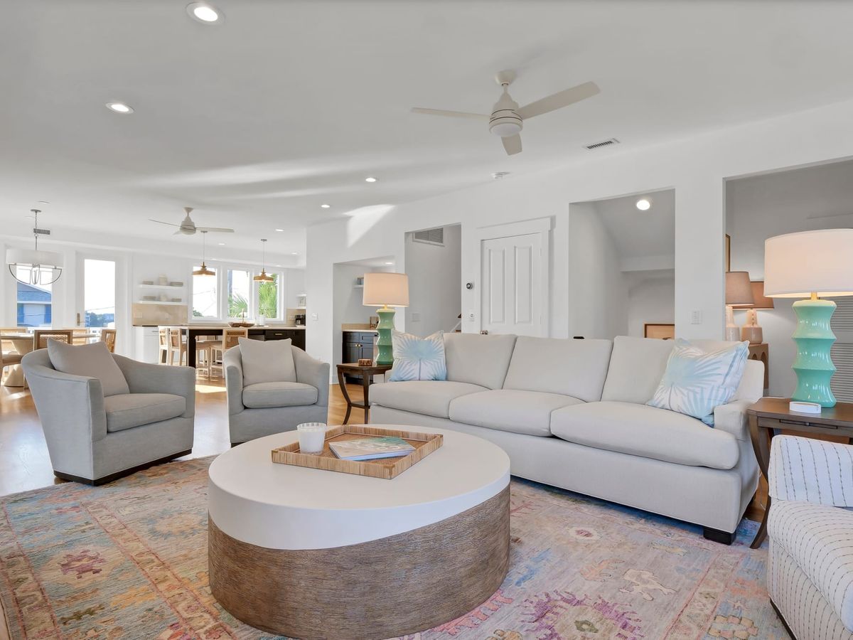 Open-concept living space features soft modern tones, a cozy couch setup, and a colorful rug for a touch of charm. It’s the kind of place where mornings start with coffee and sunshine.