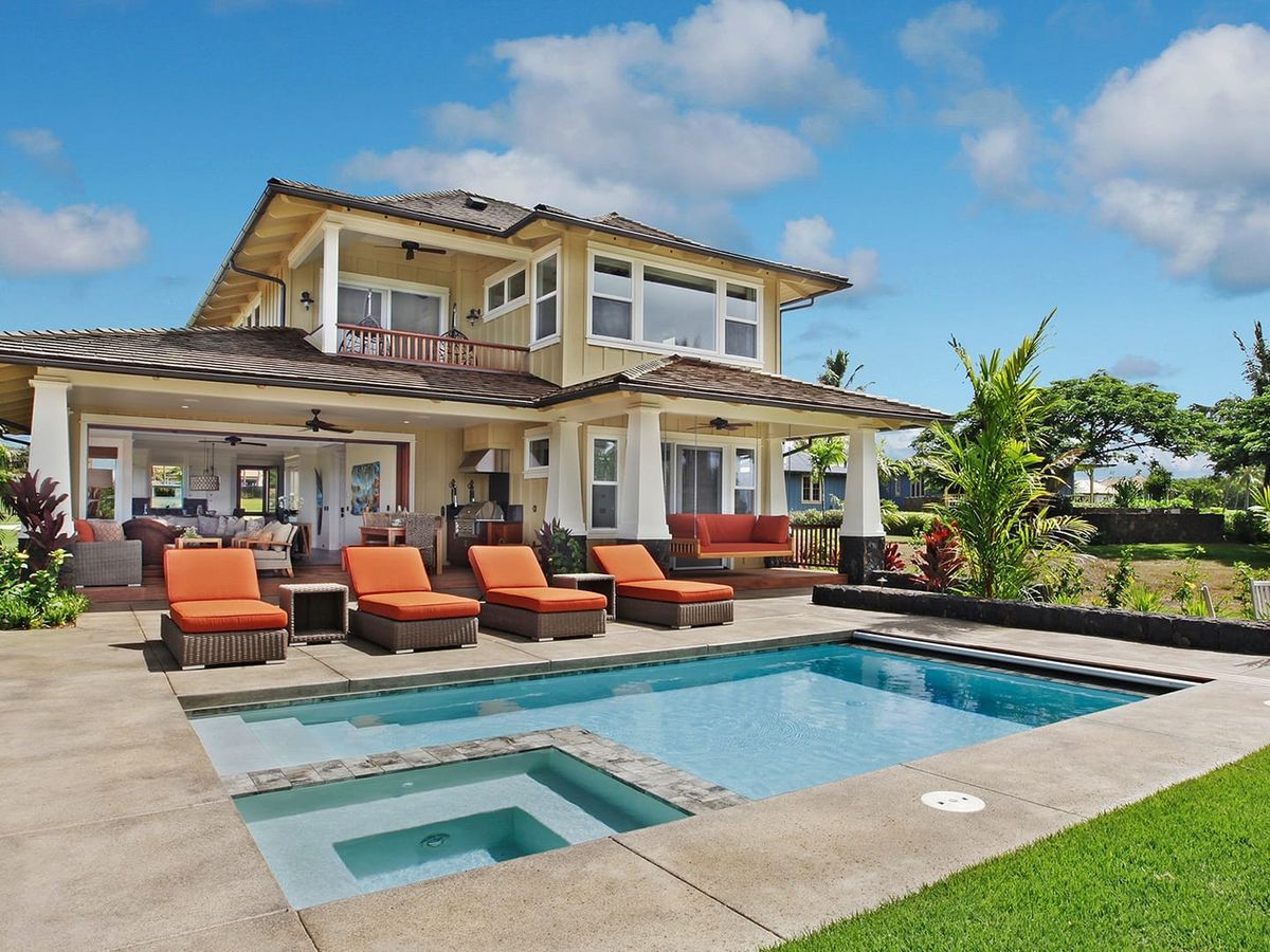 Tropical luxury meets island ease at Kukuiula Makai Cottage 36. This Hawaiian home features a sparkling pool, lush gardens, and sunny outdoor seating—perfect for lounging after a day at the beach.