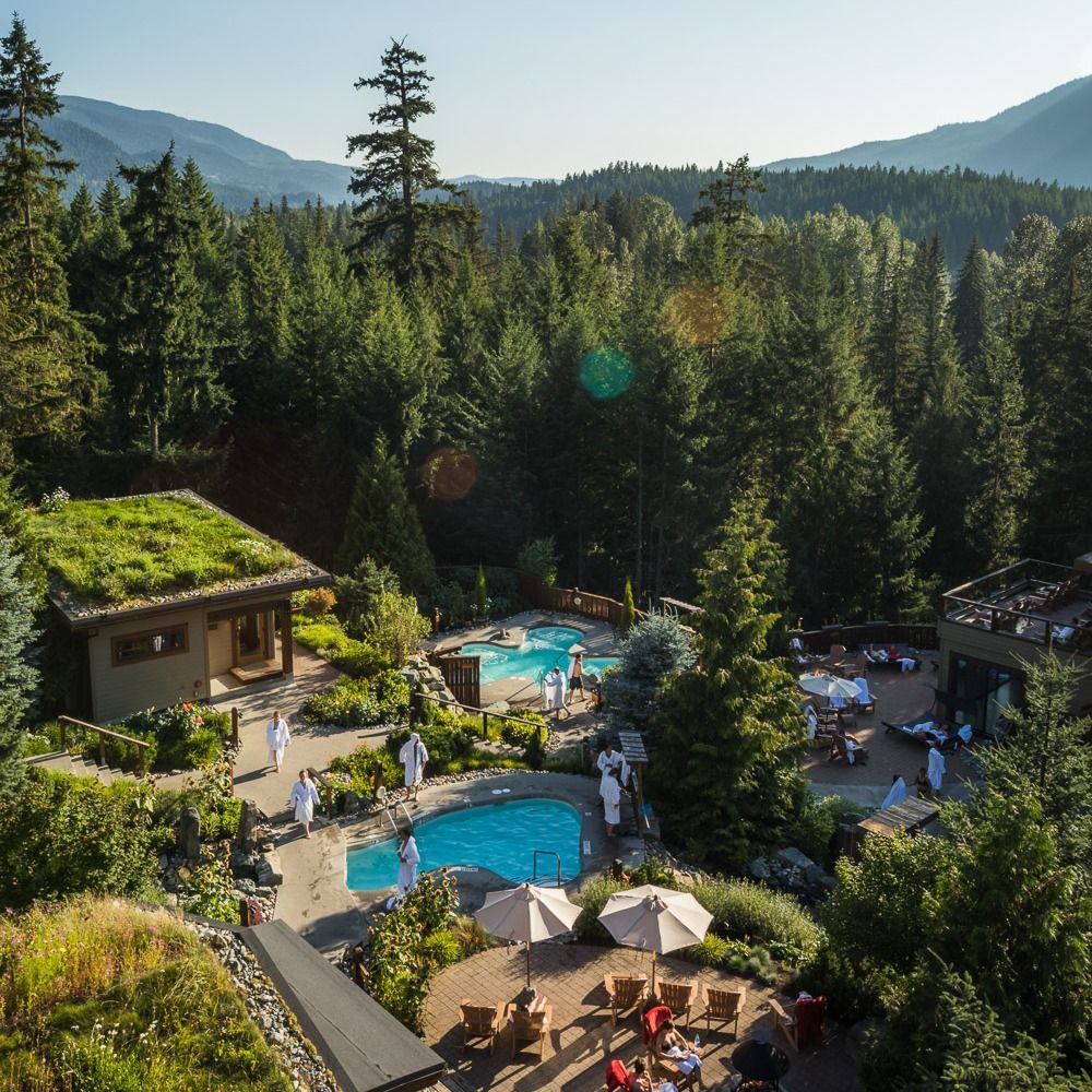 Guests relax in outdoor hot pools surrounded by tall forest trees at Scandinave Spa Whistler. The peaceful setting and mountain views create a true Nordic spa experience. It’s the perfect place to unwind after skiing or hiking in Whistler.