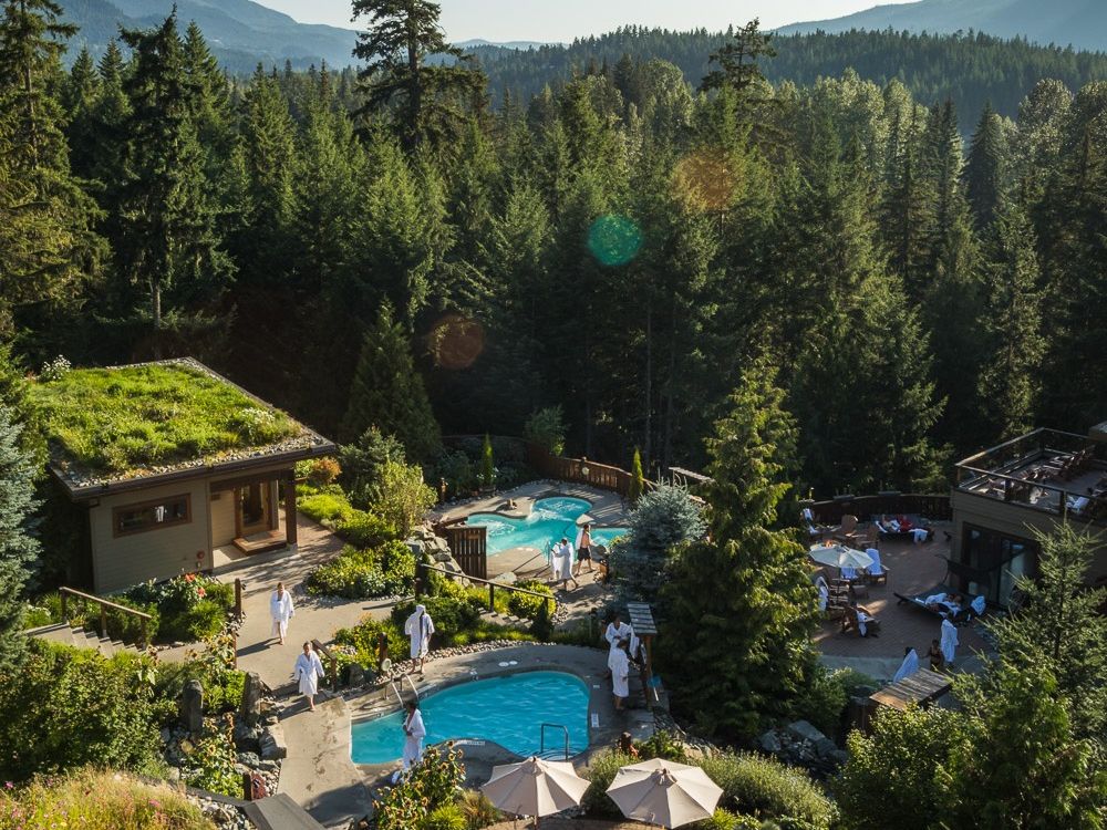 Guests relax in outdoor hot pools surrounded by tall forest trees at Scandinave Spa Whistler. The peaceful setting and mountain views create a true Nordic spa experience. It’s the perfect place to unwind after skiing or hiking in Whistler.
