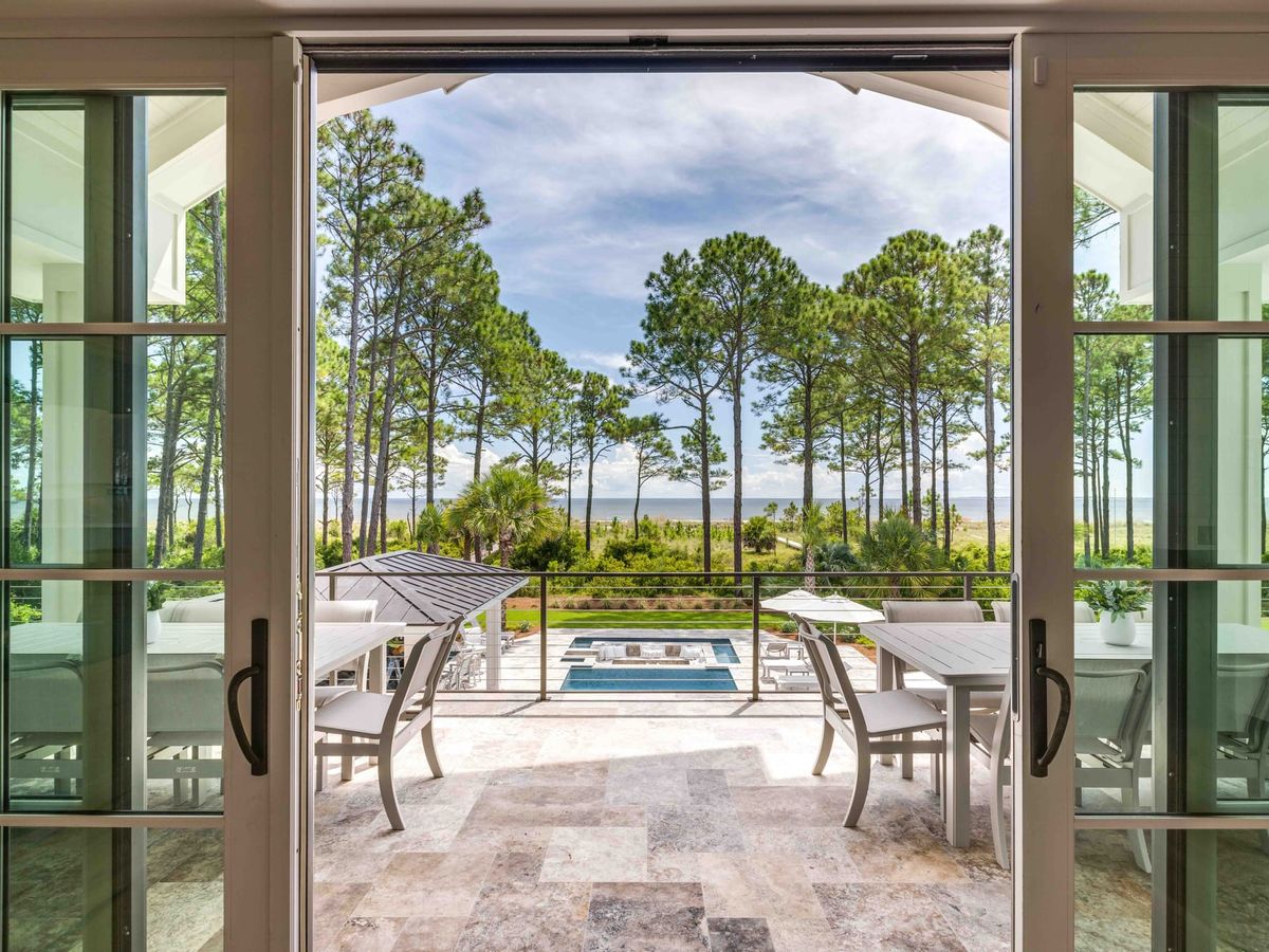 Open window to patio area with view of private pool and trees