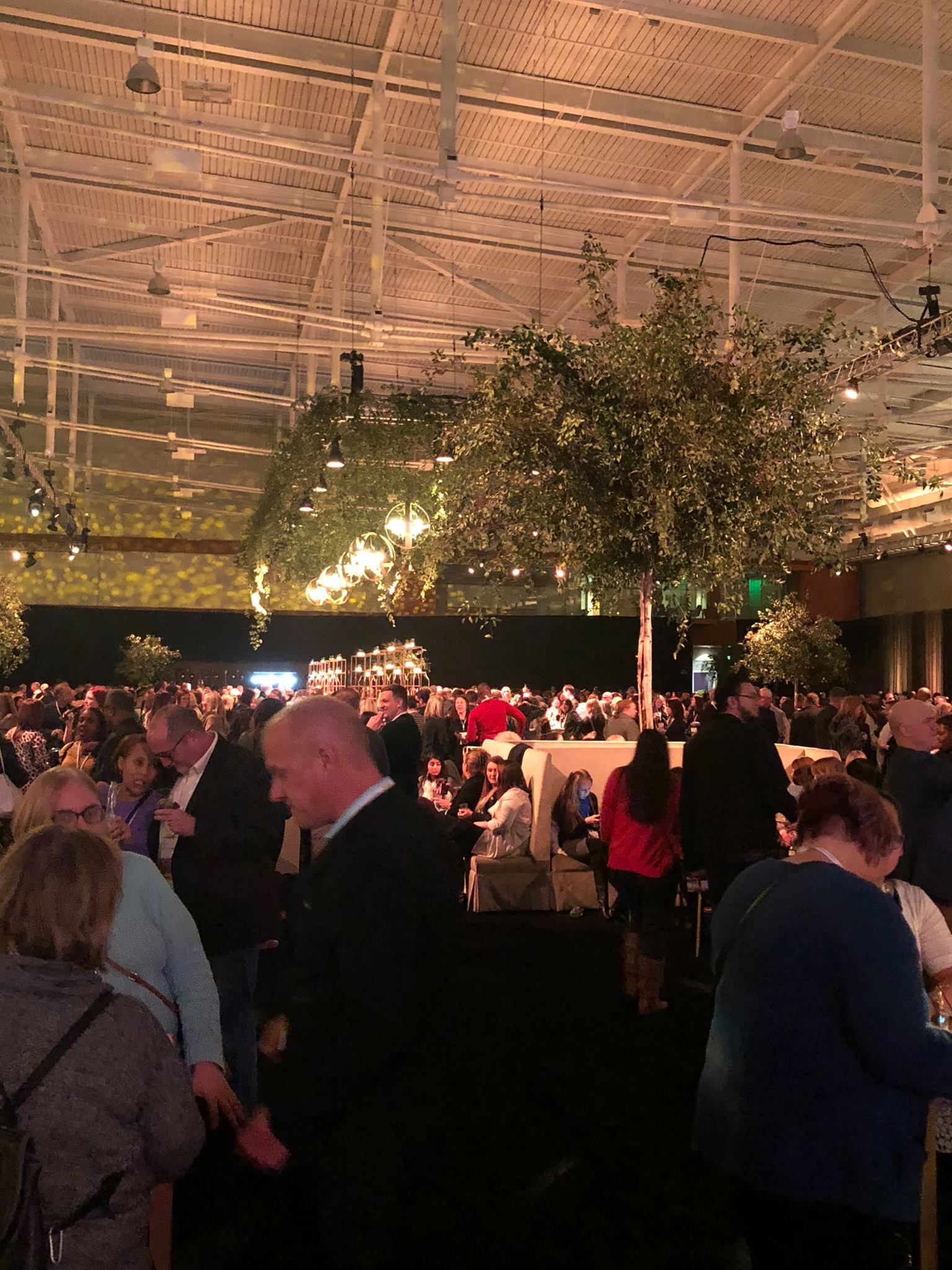 A lively rooftop party at Hyatt Nashville with guests dressed up, chatting, and enjoying drinks under warm city lights. This stylish venue is popular for nightlife, social events, and skyline views in downtown Nashville.