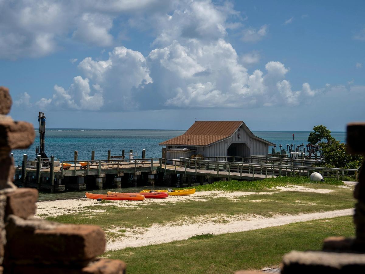 Get out on the water from a rustic dock with kayaks and a boathouse, overlooking calm turquoise seas.