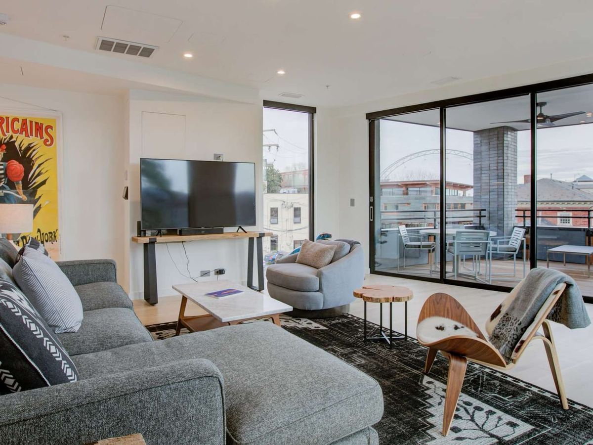 A stylish Charlottesville condo with large windows, modern furniture, and a private balcony. The open-concept layout combines comfort and sophistication, ideal for a weekend getaway.