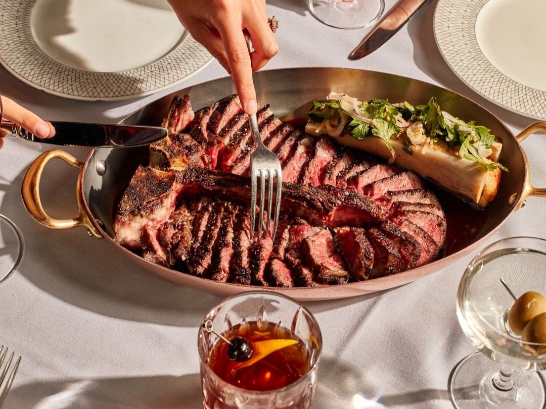 A perfectly sliced steak is served tableside at Maple & Ash, a high-end steakhouse in Scottsdale. The upscale setting and bold flavors make it a top choice for luxury dining experiences.