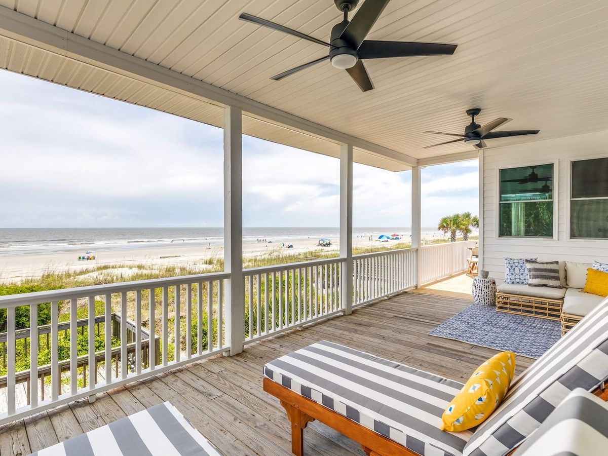 Balcony with striped lounge chairs and beachfront views