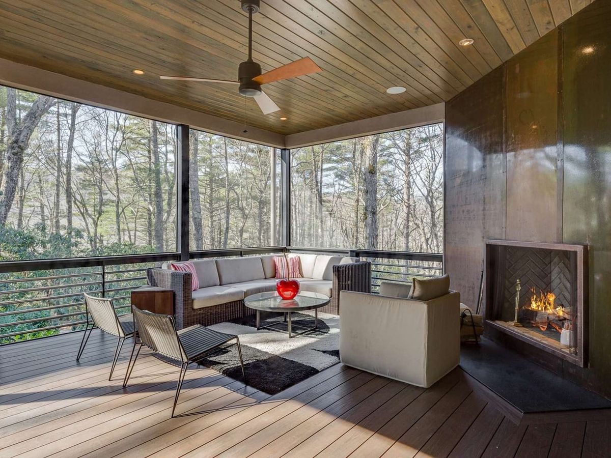 This inviting mountain cabin features high ceilings, wood beams, and a stone fireplace in a bright open living area. Large windows bring in beautiful forest views and natural light. It’s the perfect place for a cozy and comfortable mountain vacation.