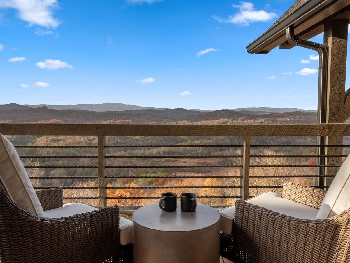 Two chairs side by side on balcony with stunning fall foliage views of the mountains in blue ridge ga