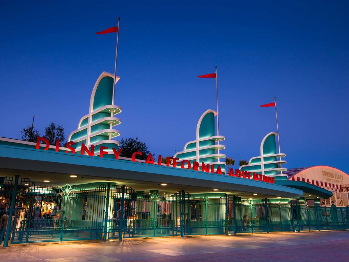 Neon-lit entrance to Disney California Adventure Park at night. A magical gateway to rides, shows, and Disney experiences.