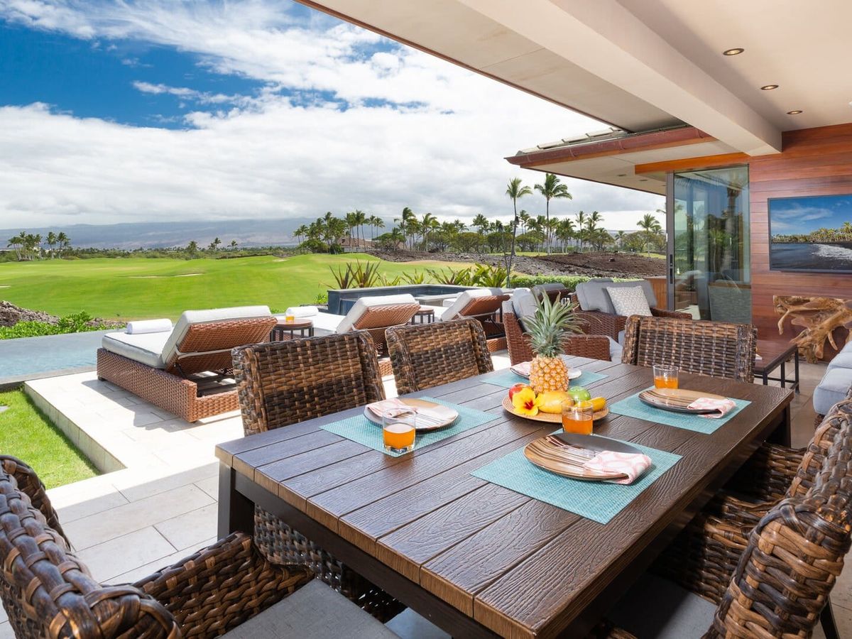 This oceanfront home sits right on the edge of the water, with tall palm trees swaying in the breeze. The open deck and large windows make the whole place feel bright and peaceful, perfect for slow mornings and sunset views.