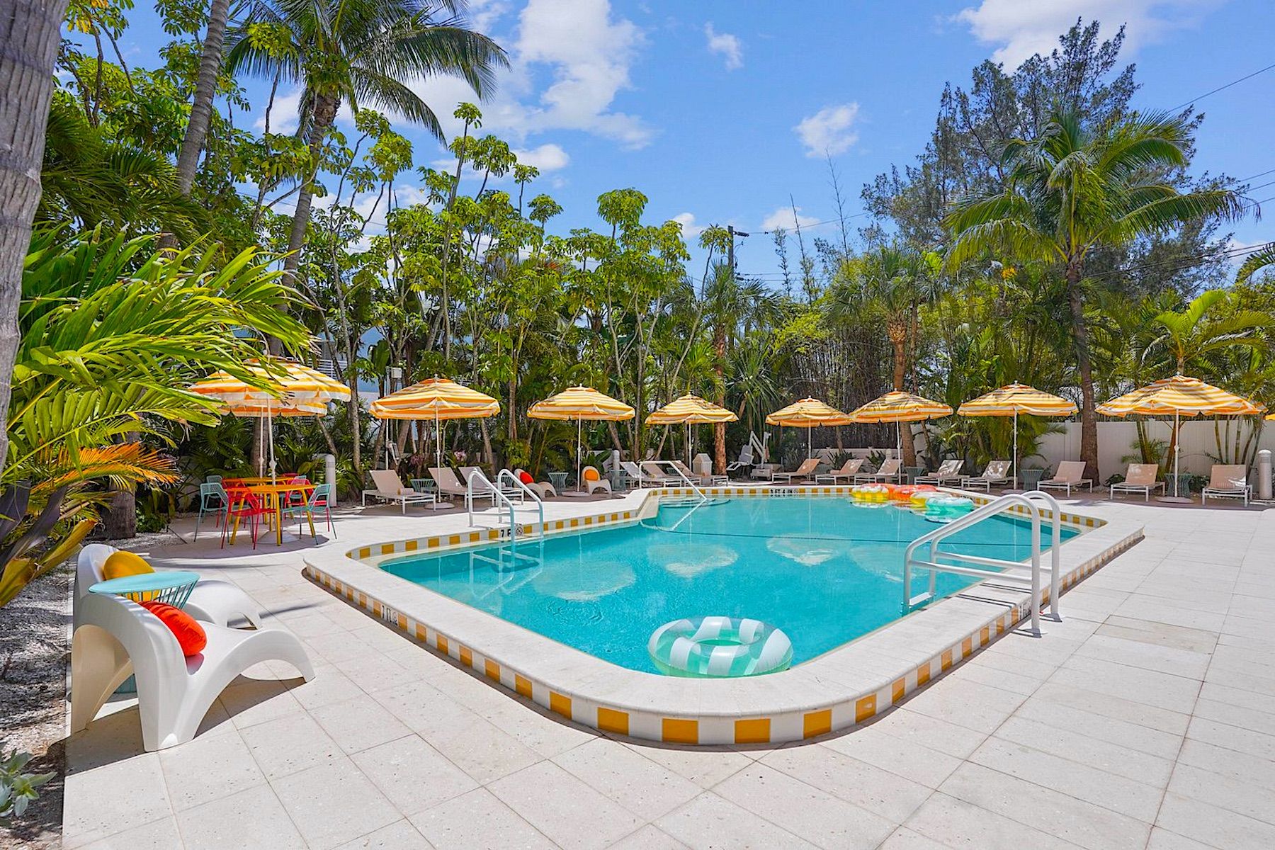 Pool With Colorful Chairs and Umbrellas at Gulf Front Anna Maria Island Condo Rentals