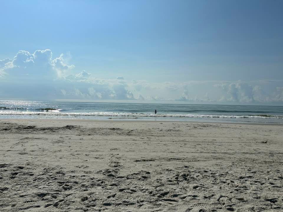 Wide sandy shoreline at Driessen Beach with gentle ocean waves and bright blue skies. A peaceful stretch of Hilton Head beach offers space for morning walks, swimming, and relaxing by the water. This quiet beach access point is perfect for families looking for a calm coastal escape.