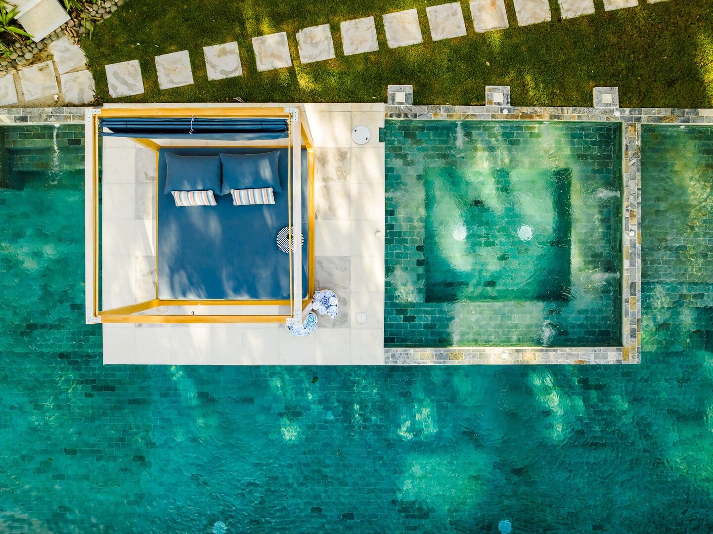 Aerial view of an elegant tropical estate with multiple villas and glowing lights surrounded by lush greenery. The property showcases the luxury, space, and privacy that define The 100 Collection experienc