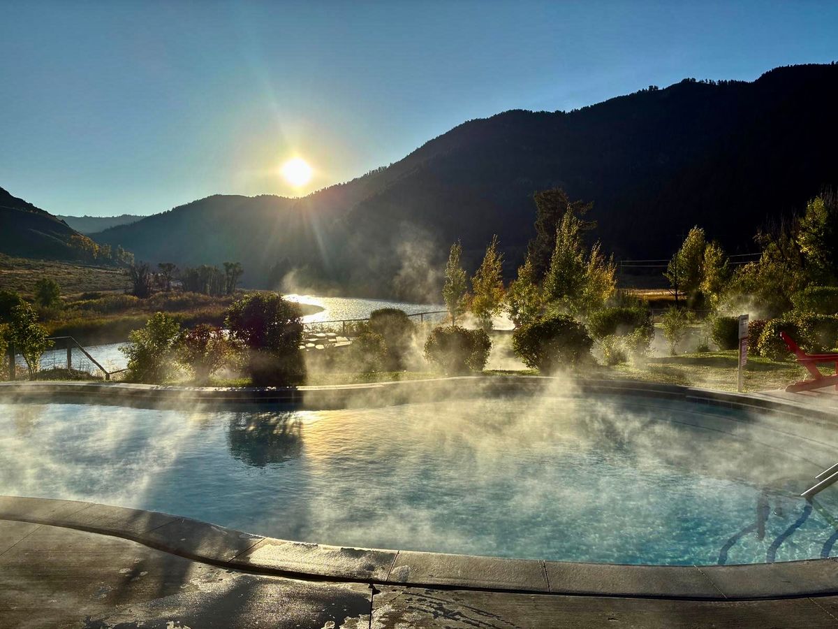 Astoria Hot Springs offers a peaceful soak with river views and mountain backdrops at sunset. Steam rises from the water as the light reflects off the surrounding landscape. It’s a calm and scenic spot near Jackson Hole.