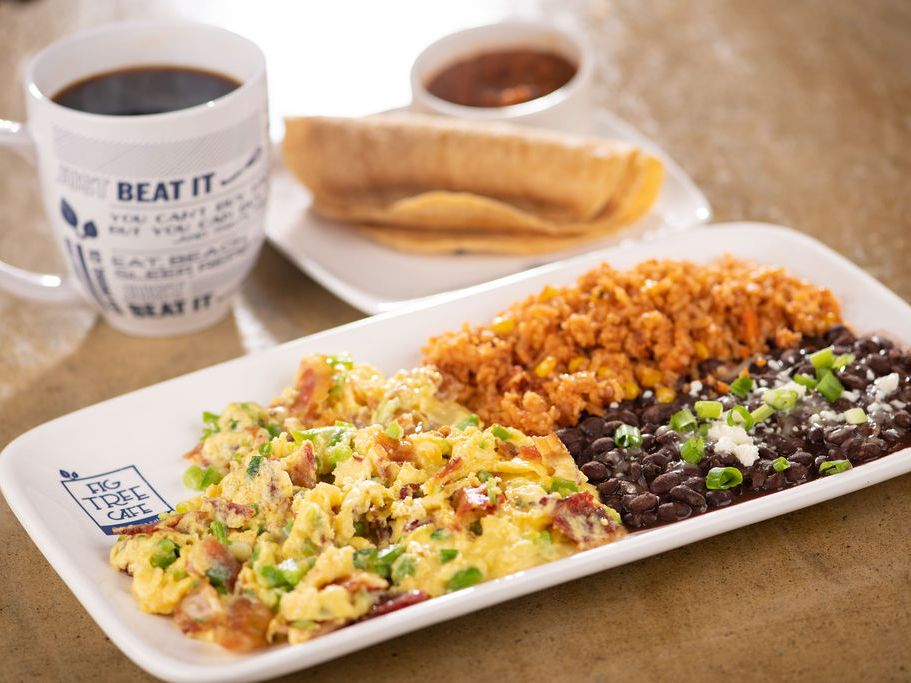 A breakfast plate at Fig Tree Café featuring scrambled eggs with bacon, black beans, rice, and tortillas, served with hot coffee. The colorful and hearty meal reflects San Diego’s love for fresh, flavorful brunch.