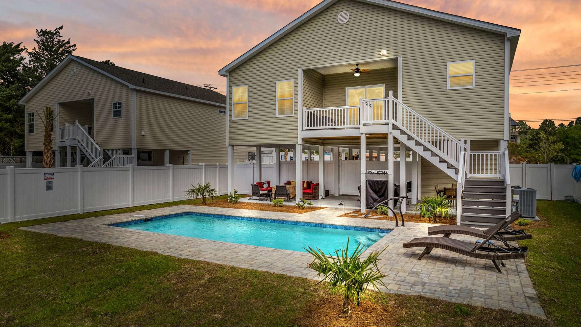 A beautiful two-story home with a sparkling backyard pool, perfect for lounging or evening swims. The open patio and sitting area make it ideal for small groups wanting a quiet beach retreat.