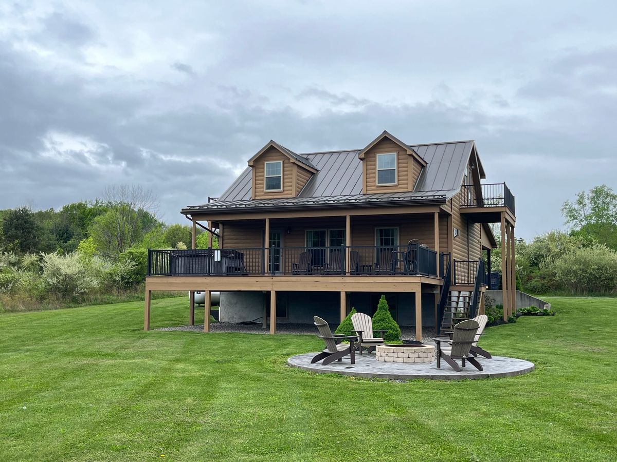 A beautiful lakefront neighborhood with docks, boats, and waterfront homes along the calm water. Trees and greenery surround the shoreline, creating a relaxing natural setting. The Finger Lakes region is known for scenic lakes, boating, and peaceful waterfront retreats.