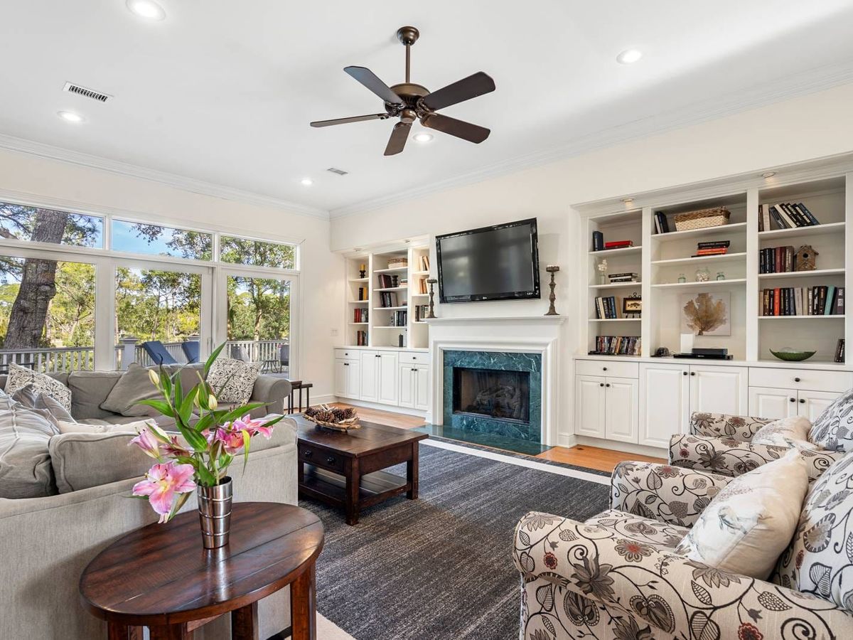 Cozy living room with a fireplace and large windows that bring in natural light. This space is ideal for family movie nights or relaxing after a day at the beach.