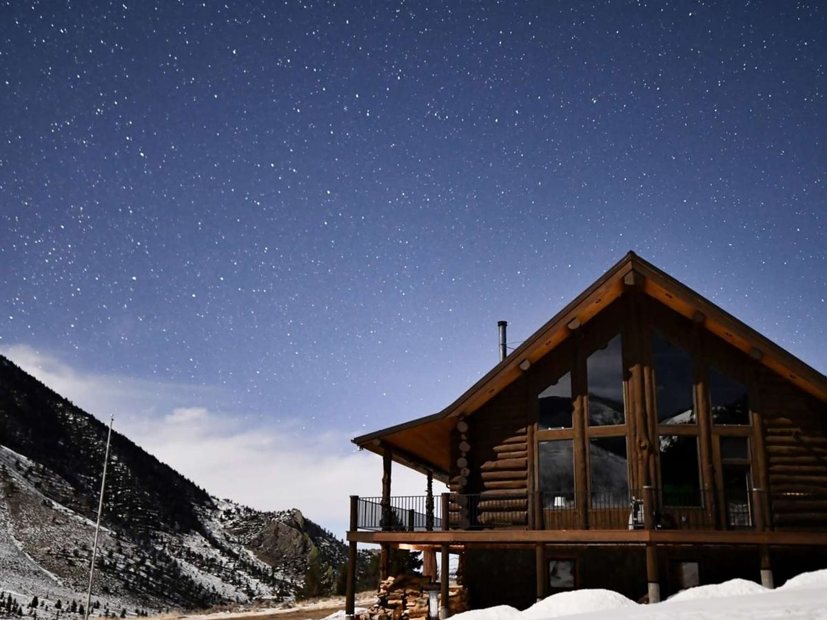This mountain cabin glows under a starry night sky, with snow all around and peace in the air. Perfect for anyone looking to escape, unplug, and fall asleep to the quiet of Montana's wilderness.
