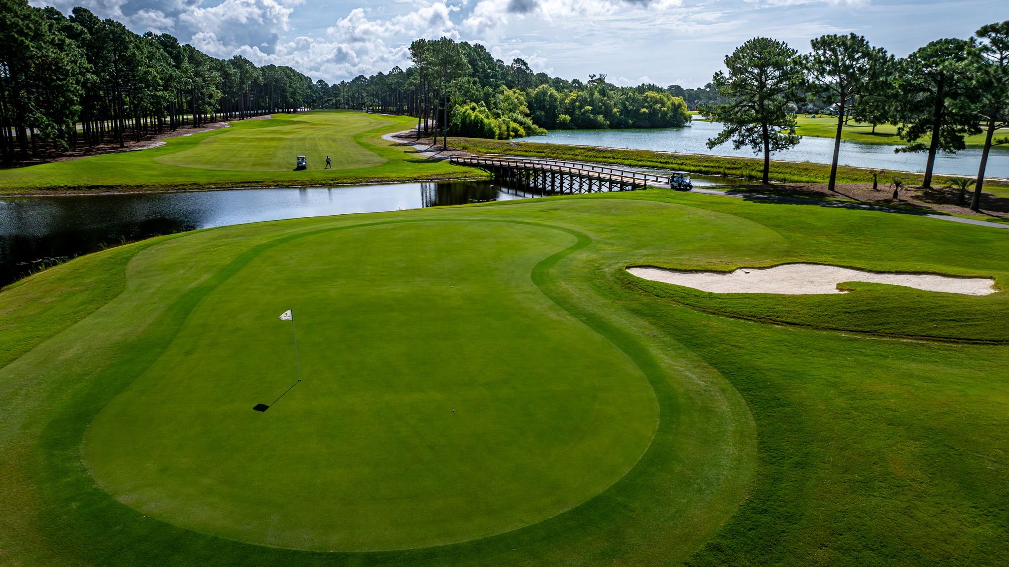 A wide fairway at Sea Trail Golf Resort features smooth greens, a wooden bridge, and water views. This coastal golf course is perfect for a laid-back and scenic round.