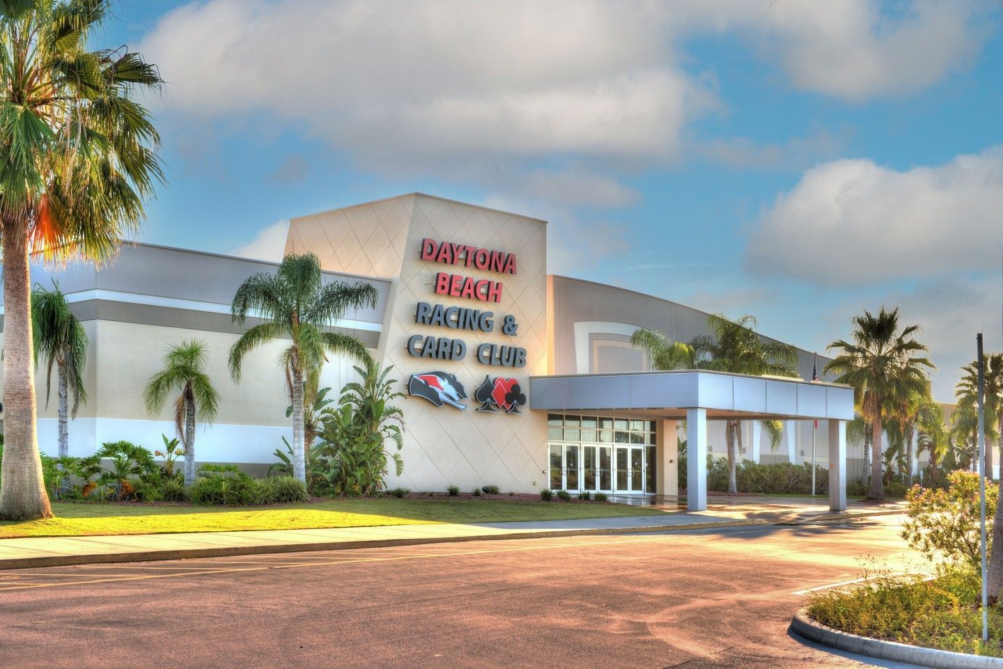 The modern exterior of the Daytona Beach Racing & Card Club gleams under the Florida sun, framed by palm trees and blue skies. This iconic spot highlights the city’s love for speed, excitement, and entertainment.