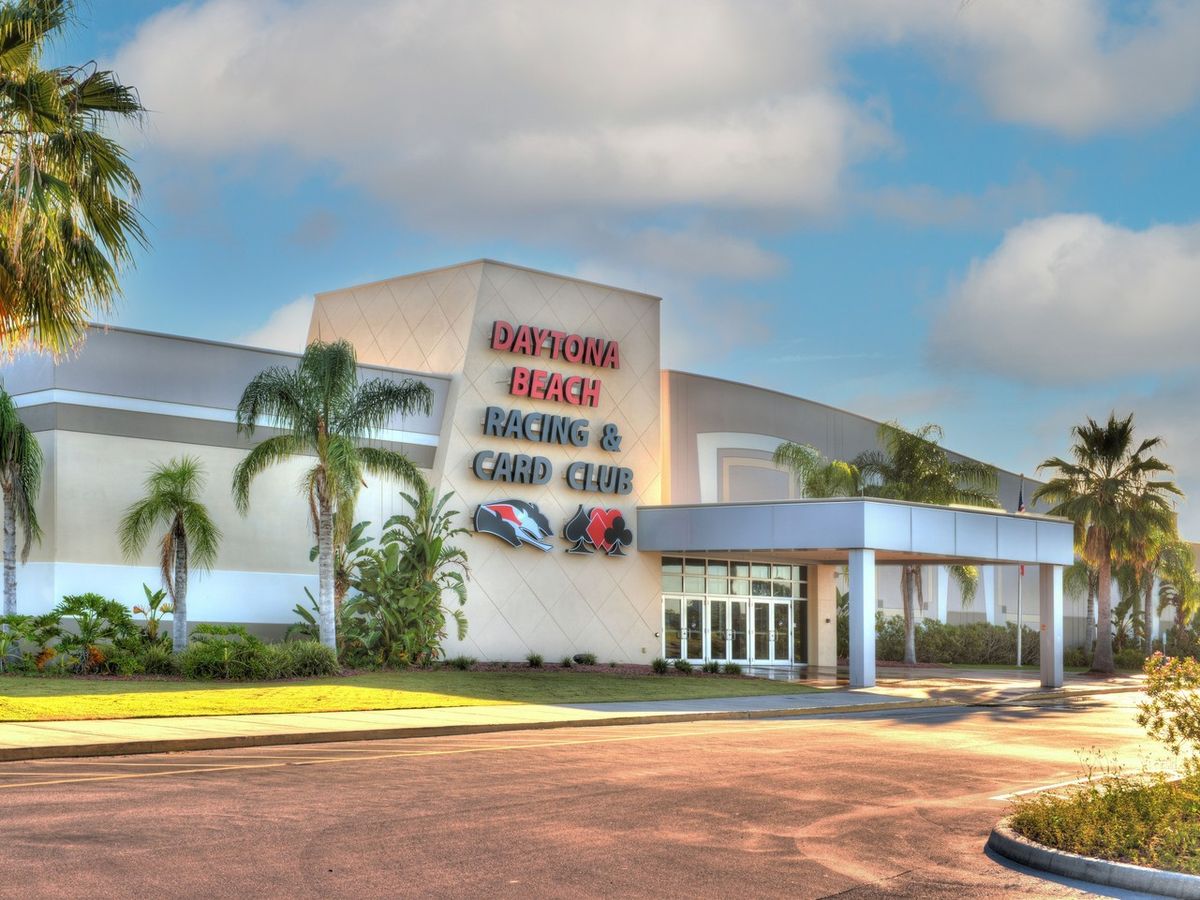 The modern exterior of the Daytona Beach Racing & Card Club gleams under the Florida sun, framed by palm trees and blue skies. This iconic spot highlights the city’s love for speed, excitement, and entertainment.