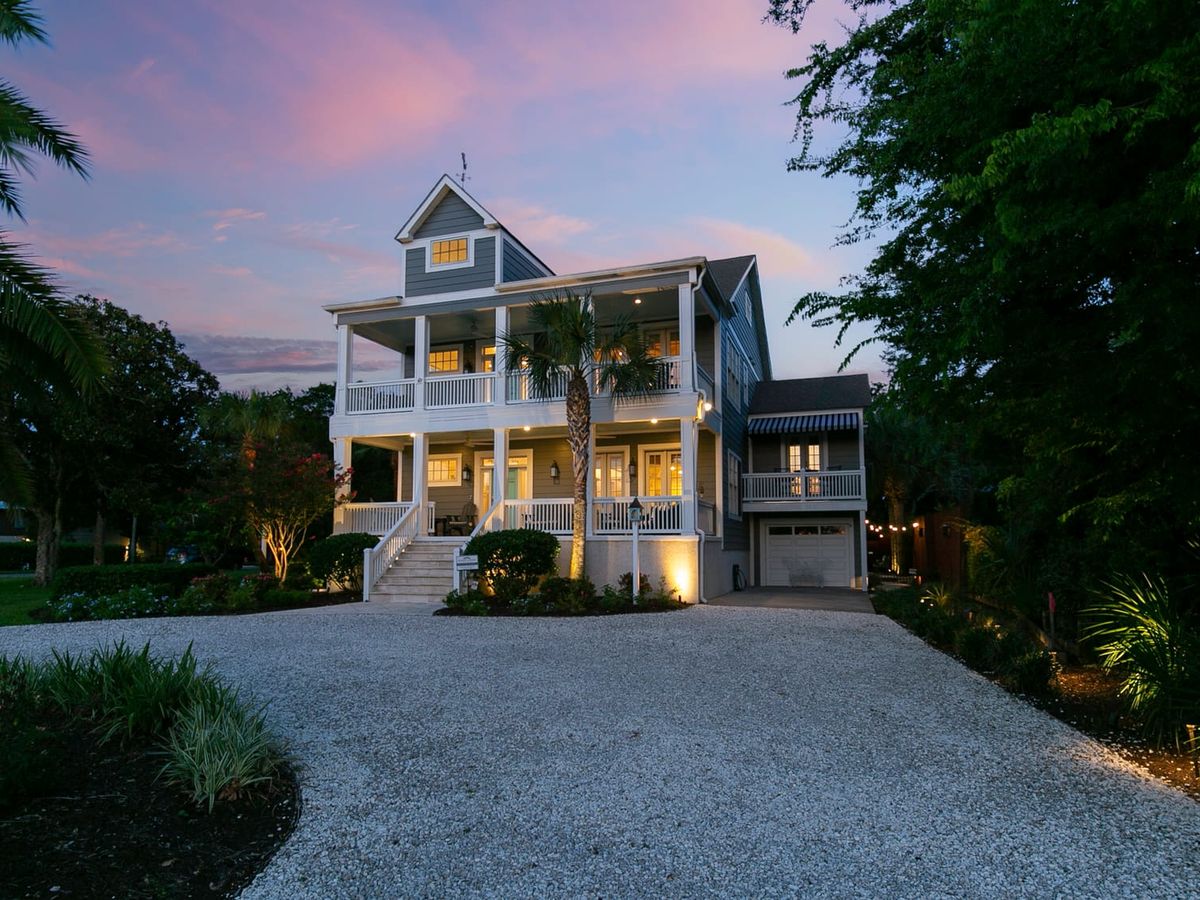 A stunning coastal home with wraparound porches, palm trees, and soft pink skies at sunset. Perfect for families or groups, it offers the charm of Southern architecture near St. Simons Island’s beaches.