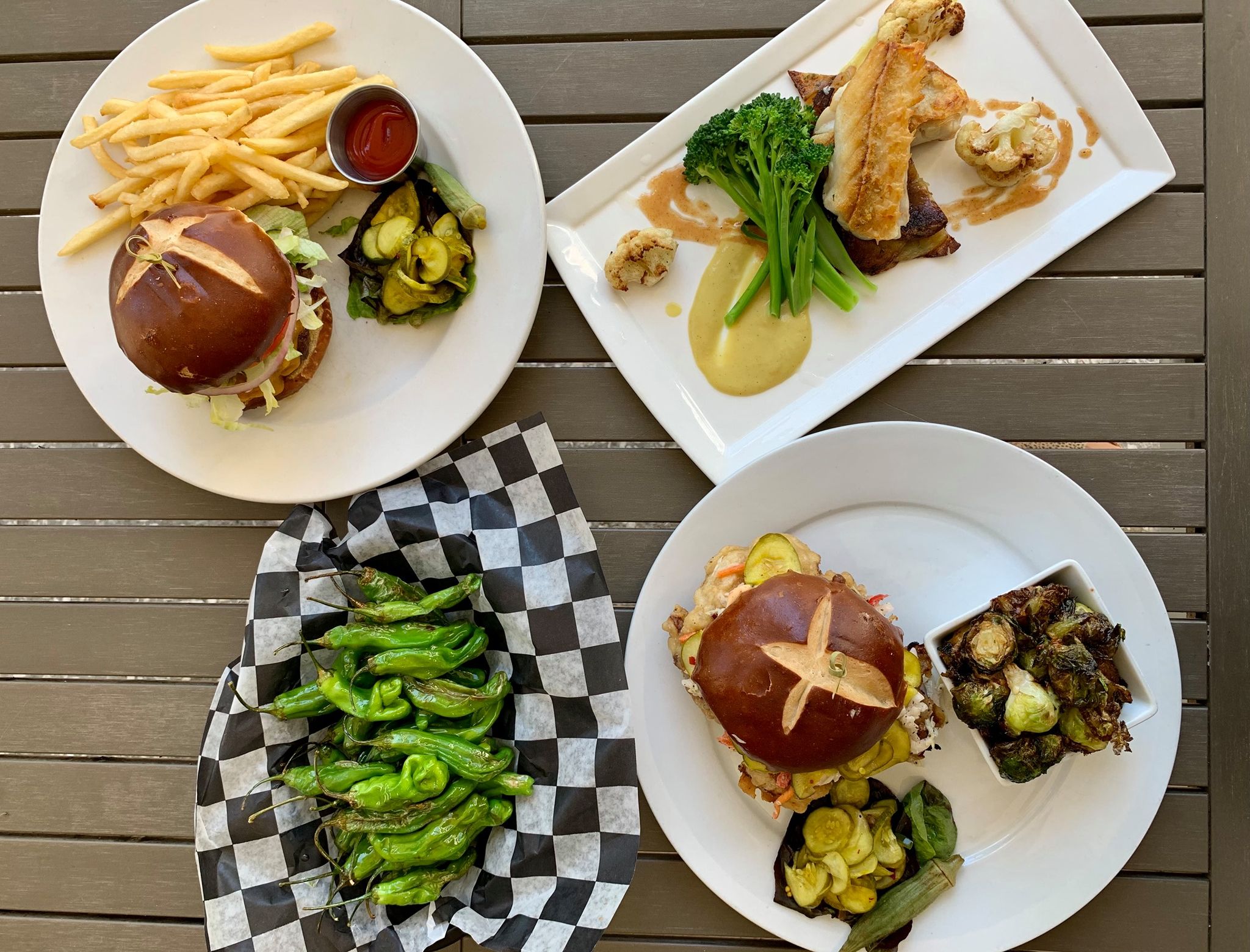 A spread of comfort food at Cherrywood BBQ and Ale House, including burgers, fries, roasted vegetables, and shared plates. This local spot is popular for casual dining, bold flavors, and craft beer.