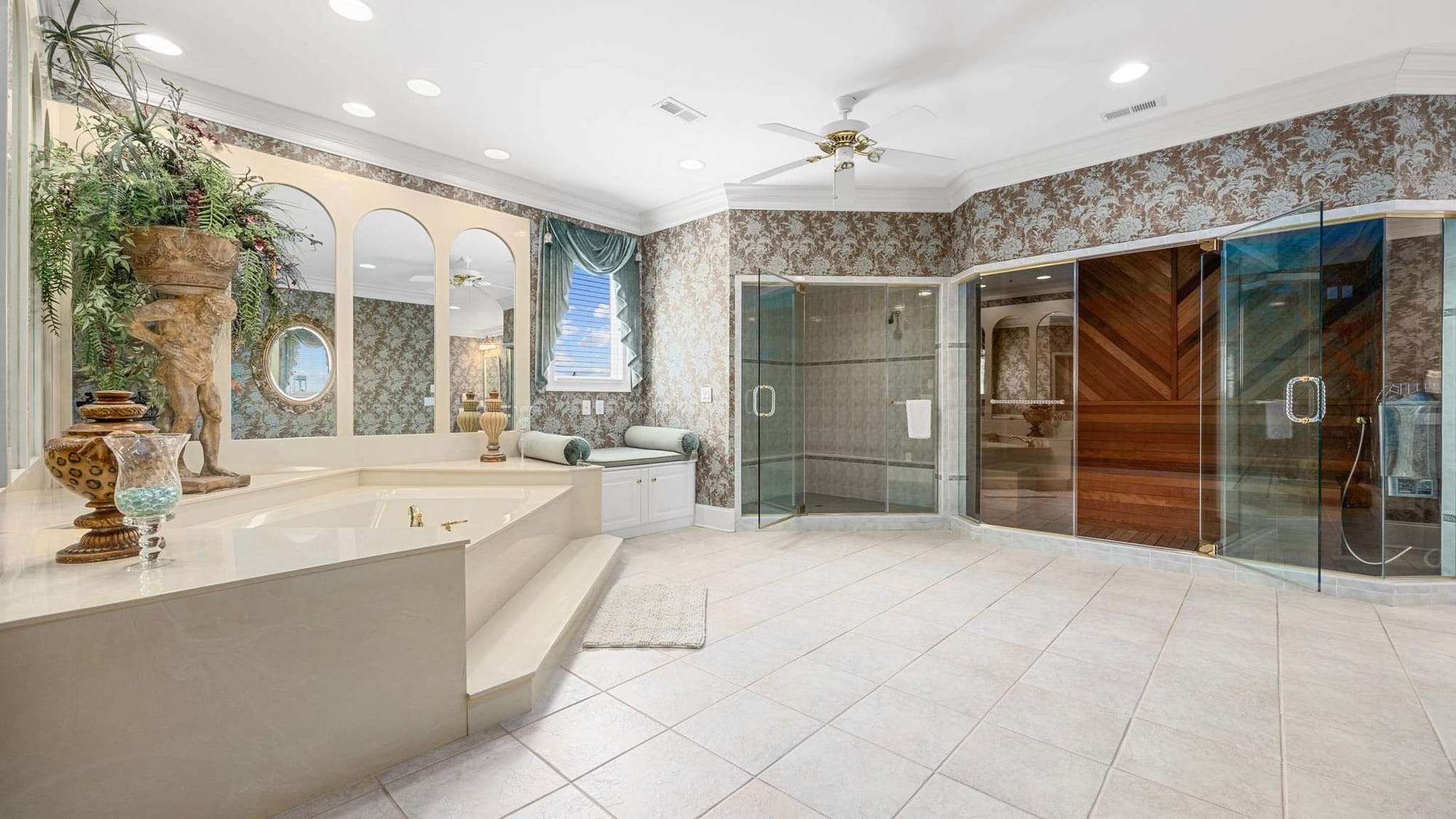 A spacious luxury bathroom at Palmetto Sunset features a large soaking tub, walk-in shower, and private sauna. The bright, spa-like space gives guests plenty of room to relax during a group beach vacation.