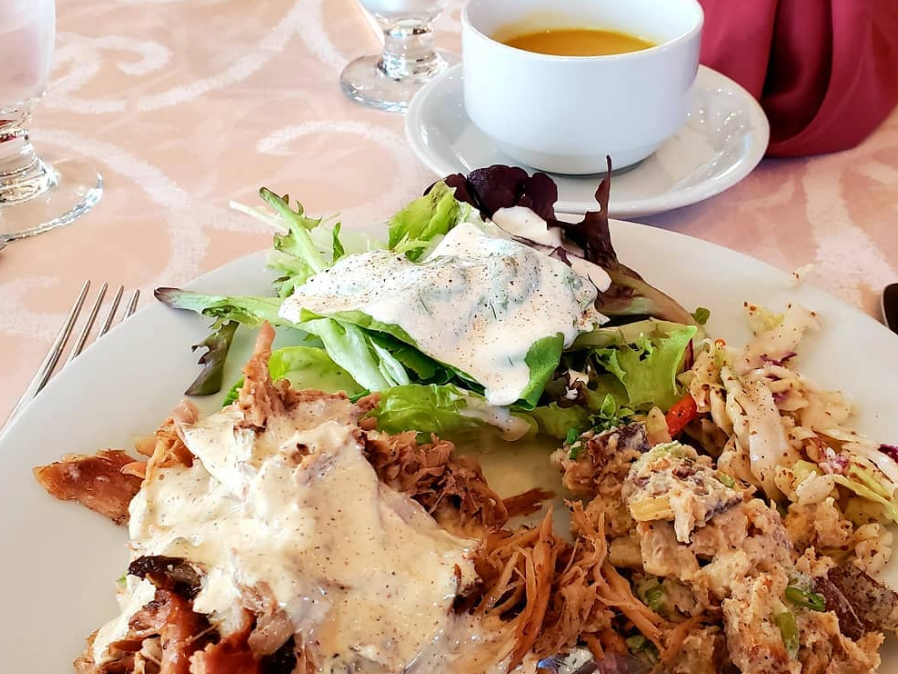 BBQ smothered in sauce with salad and side with water in glass