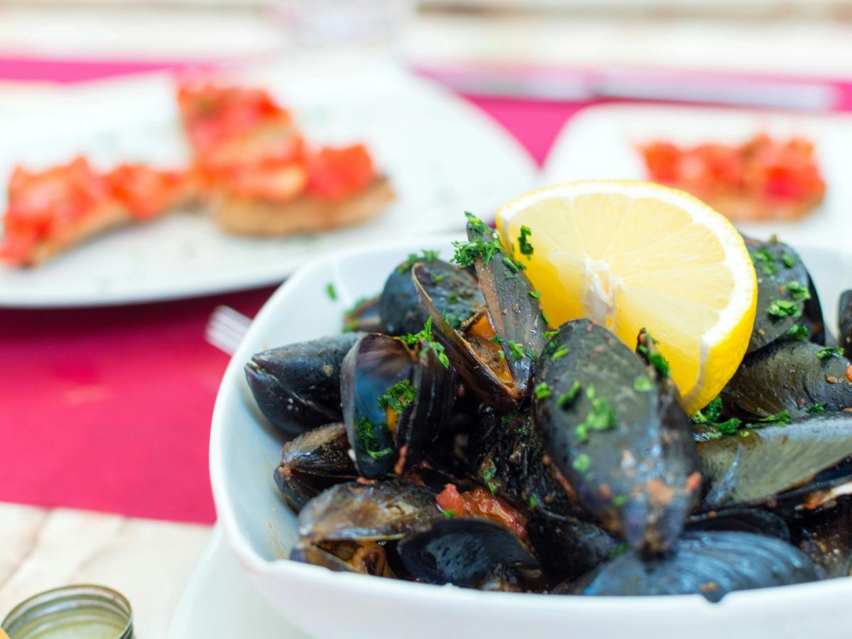 Lemon wedge on seafood platter in white bowl on top of table
