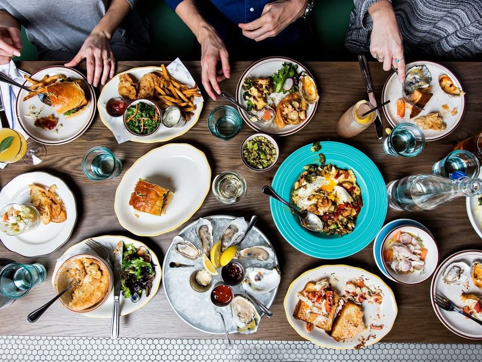 A lively seafood brunch table packed with oysters, tacos, salads, and drinks. A great place to gather with friends and enjoy fresh coastal bites.