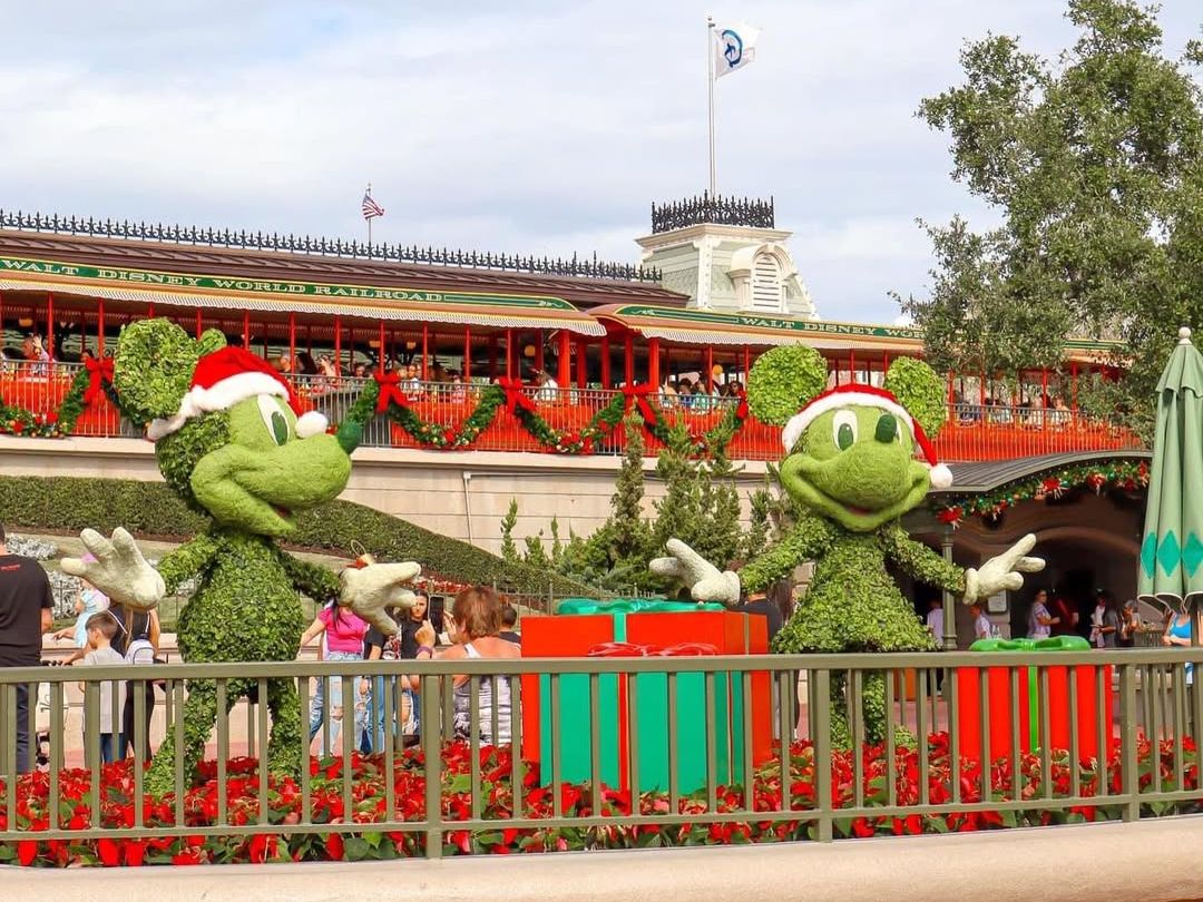 Mickey and Minnie topiary figures decorated for Christmas at Walt Disney World Railroad entrance. A festive welcome to one of the best amusement parks in the U.S.