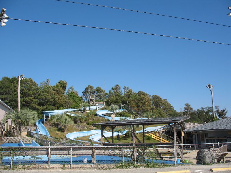 Blue water slides twist through the trees at Magic Mountain Fun Park, a classic family spot for cooling off and having fun in Holden Beach.