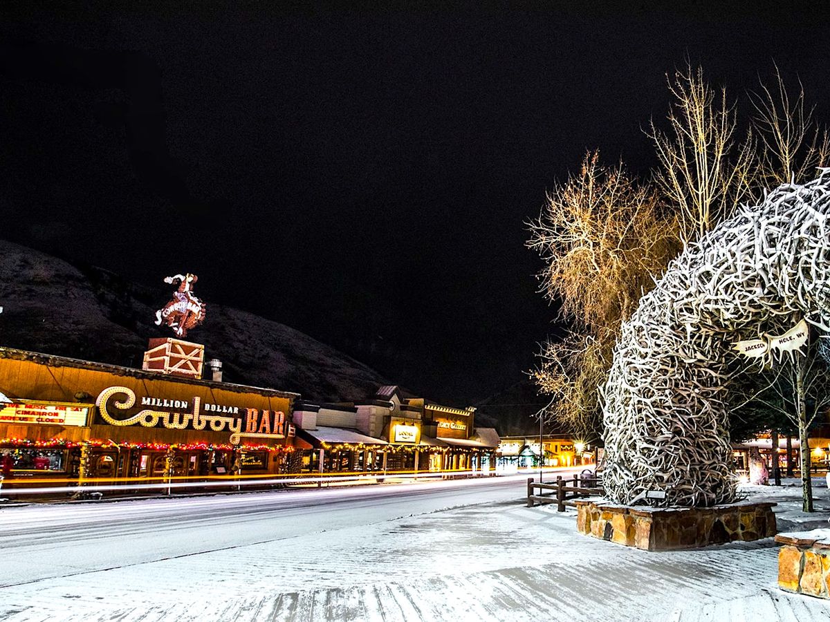 Jackson Hole, WY downtown boardwalk area and antler arch at night in the winter.