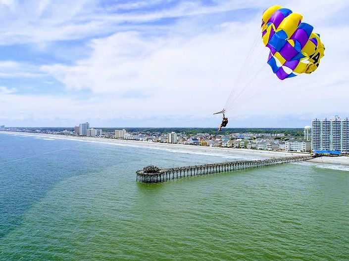 Parasailing high above the ocean with Aloha Watersports in North Myrtle Beach, enjoying sweeping views of the coastline and Cherry Grove Pier.