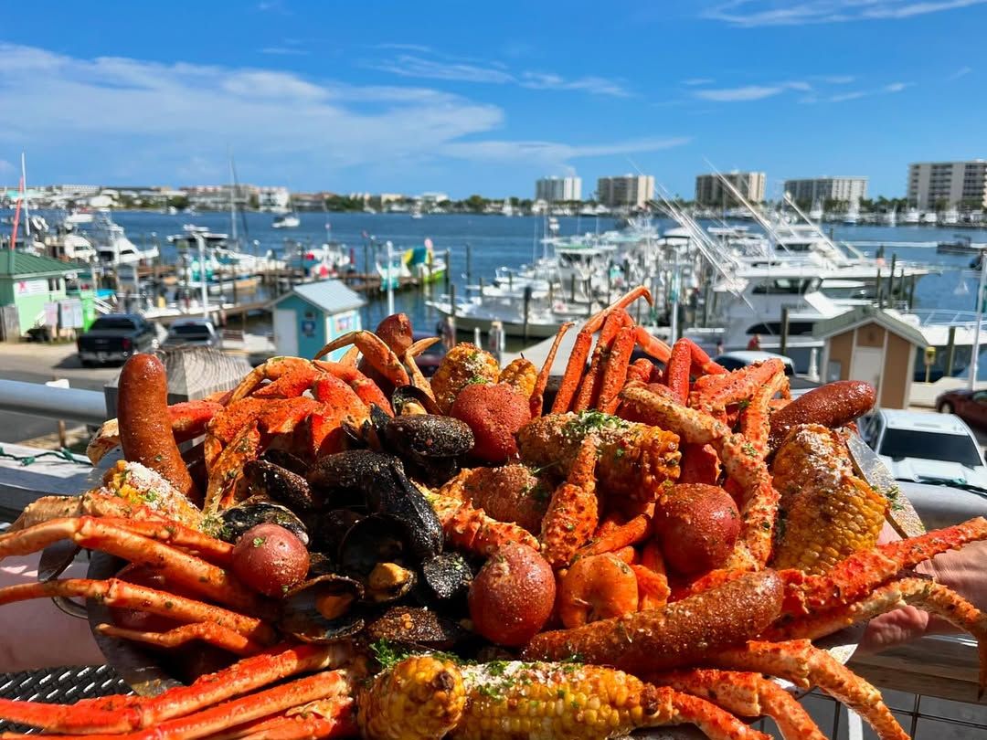 A loaded seafood boil piled high with crab legs, shrimp, mussels, sausage, and corn, overlooking Destin Harbor. Brotula’s delivers big flavor with unbeatable marina views.