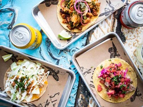 Colorful street tacos served on rustic trays at Papi’s Taqueria with fresh toppings like cabbage, onions, and salsa that scream beach vibes. A must-stop for taco lovers on Sullivan’s Island.