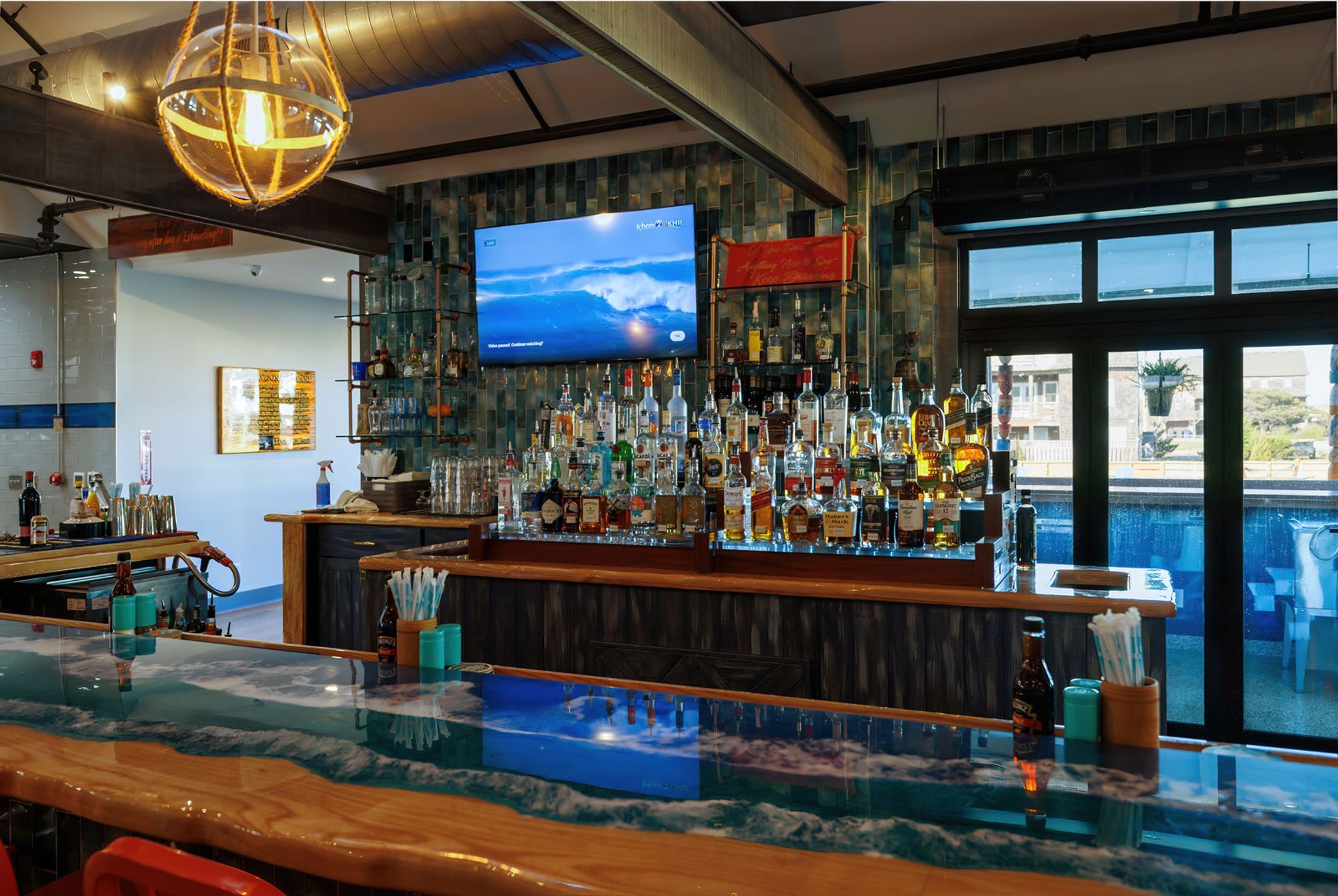 Ocean Boulevard’s stylish bar area features a surf-themed counter and a huge liquor selection. The vibe is laid-back yet upscale, perfect for sipping cocktails while watching the waves roll in on the screen