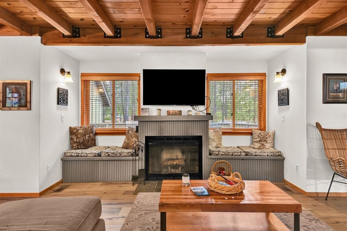A bright and inviting getaway with open living spaces and large windows that frame the forest views. The living room’s wood accents and fireplace create a welcoming spot to unwind, while the outdoor patio offers plenty of room for family gatherings. Ideal for guests who want a peaceful stay close to nature.