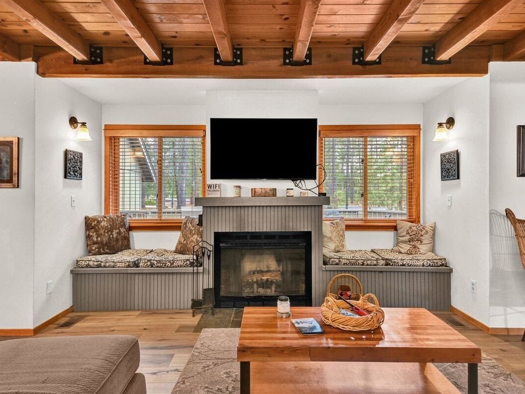 A bright and inviting getaway with open living spaces and large windows that frame the forest views. The living room’s wood accents and fireplace create a welcoming spot to unwind, while the outdoor patio offers plenty of room for family gatherings. Ideal for guests who want a peaceful stay close to nature.