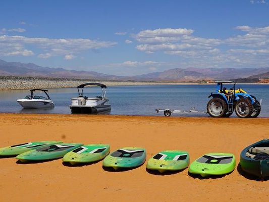 Kayaks, boats, and paddleboards line the sandy shore of Sand Hollow State Park, a favorite Utah spot for swimming and water sports.