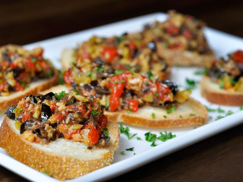 Crispy crostini topped with a savory olive, tomato, and herb mix at The Stubborn Mule. A flavorful appetizer that pairs perfectly with cocktails.