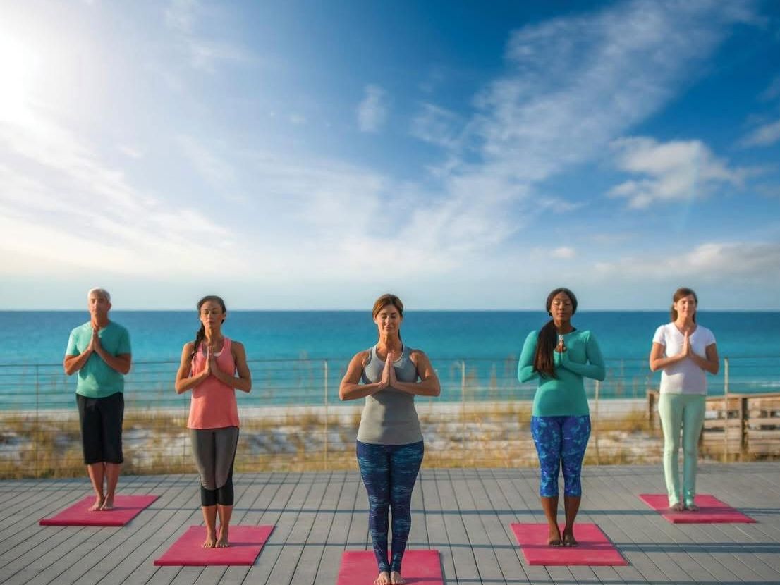 Beachfront outdoor yoga class at Serenity by the Sea Spa in Miramar Beach, Florida overlooking the Gulf of Mexico.