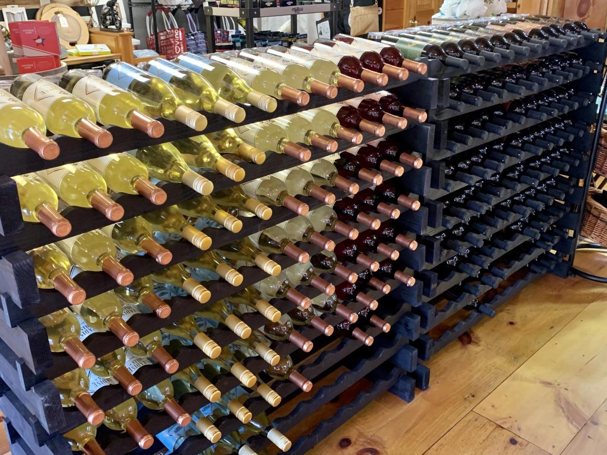 Neatly stacked rows of wine bottles fill this display inside Georgia Wine Depot. The lighting highlights the rich colors of both white and red wines. It gives a sense of abundance and discovery for anyone browsing the collection.