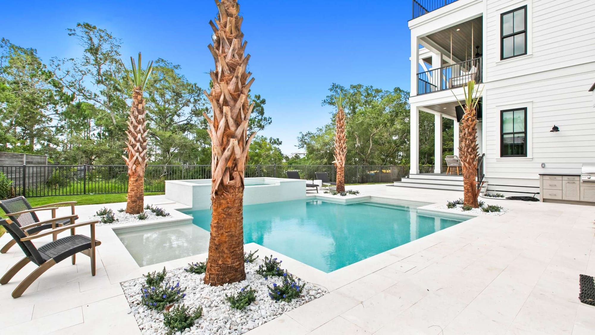 A private backyard pool with clean stone decking, palm trees, and a modern coastal home at South Lake View. This outdoor space is perfect for relaxing after the beach, with plenty of room to lounge, swim, and enjoy the quiet coastal setting.