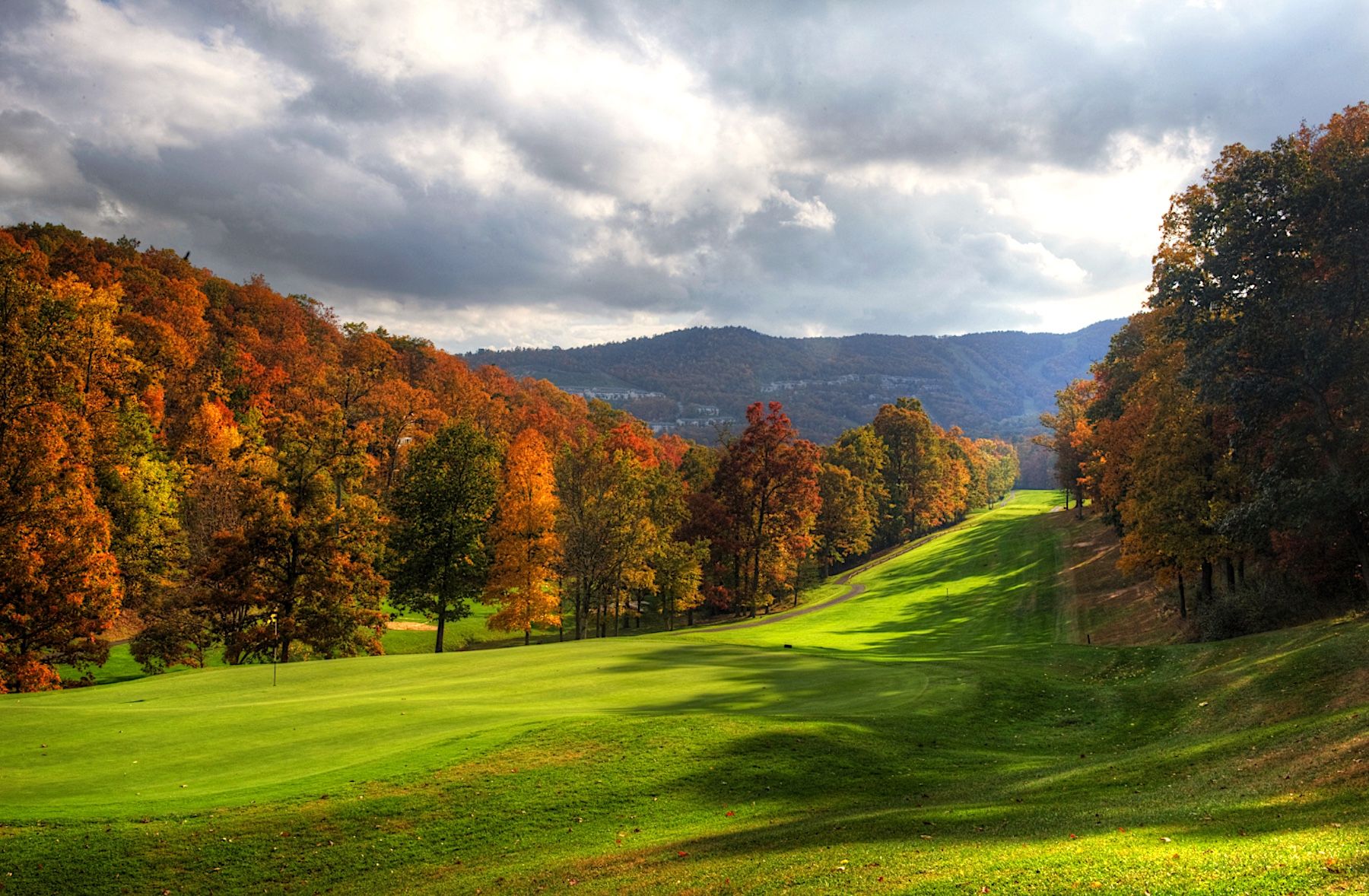 Massanutten Golf Course with mountains in the background surrounded by fall foliage