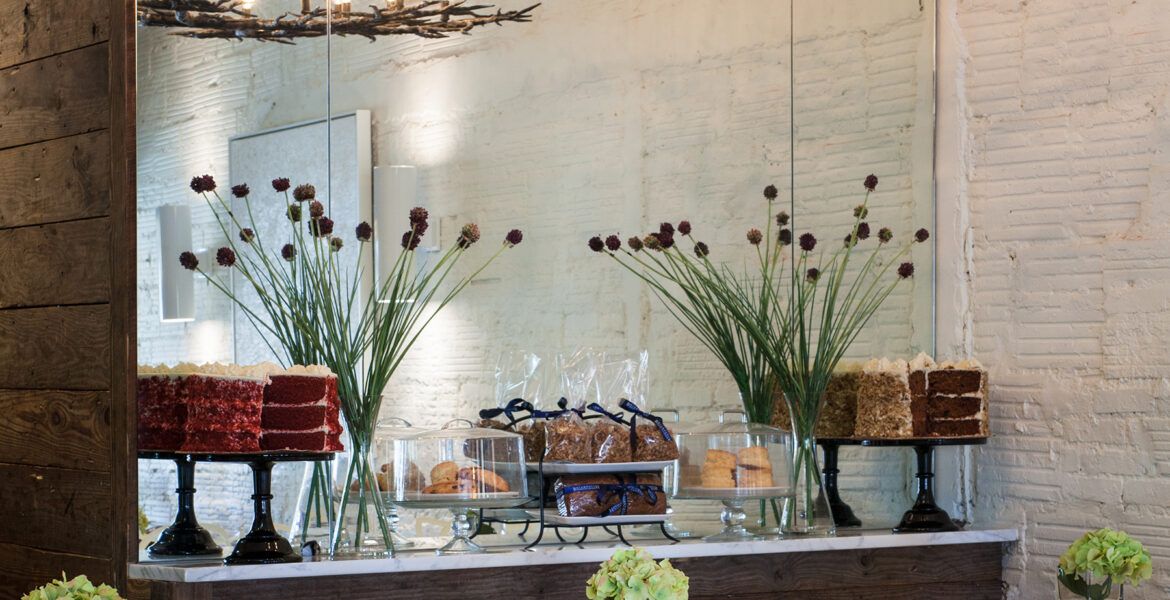 A bright brunch plate with eggs benedict, fresh berries, a latte, and a chilled drink sits on a pink table in the sunshine. The creamy hollandaise and colorful fruit make the meal look warm and inviting. This cozy setup captures the sweet, relaxed vibe of a weekend morning.